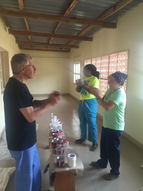 Howard, Jemella, and Randi shaking up the paint cans before starting our works of art. The only type of paint available was oil-based paint, and there were very limited colors. So we did a lot of mixing in the plastic cups you see here. As a result, the playroom is a vibrant mix of all colors, shades, and hues.